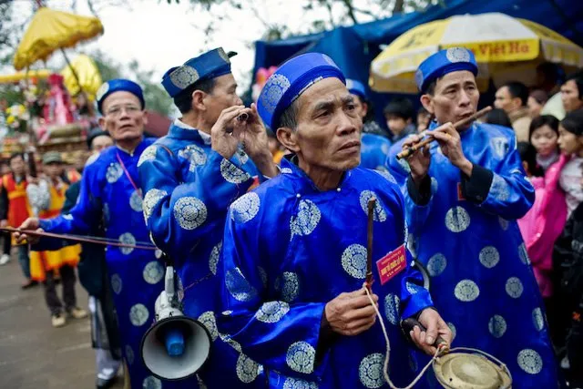 Ảnh chụp một nhóm nam giới chơi nhạc cụ truyền thống tại lễ hội làng Đồng Kỵ